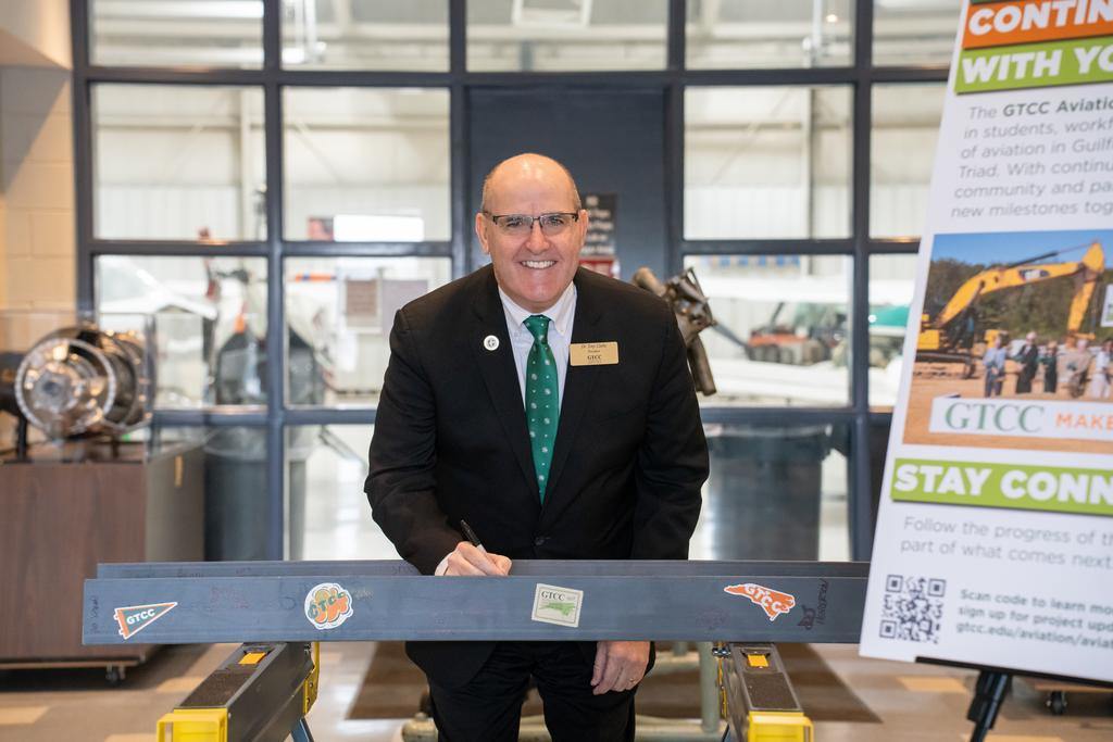 Dr. Anthony Clarke signing the final GTCC Aviation Center beam