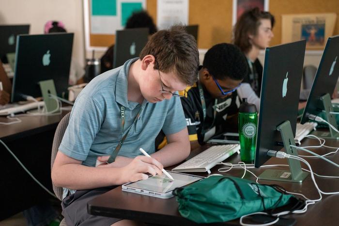 Graphic design students drawing on tablets with digital pens