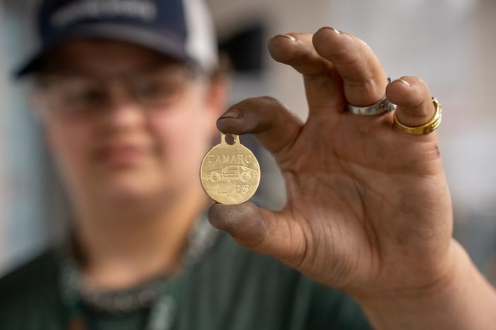 Metal Machines student holding up a metal chess piece they created