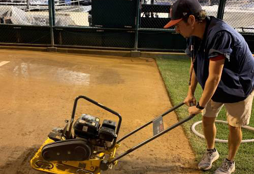 Luke Montgomery uses equipment to prepare a ball field.
