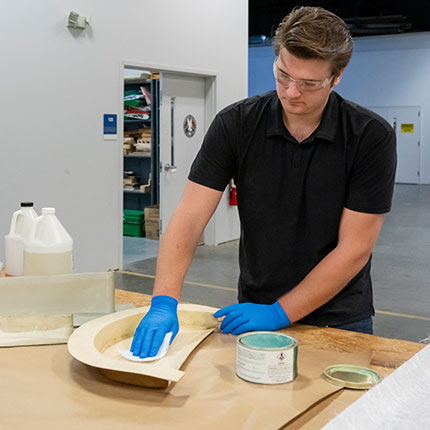 A aerospace manufacturing program white male students works on a project in the lab.