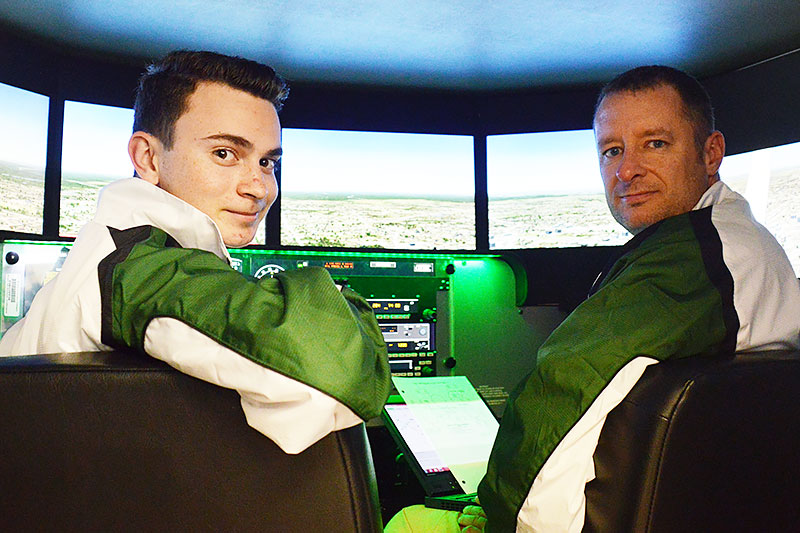 Student and instructor look back from cockpit.