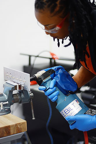 Student installing blind rivets