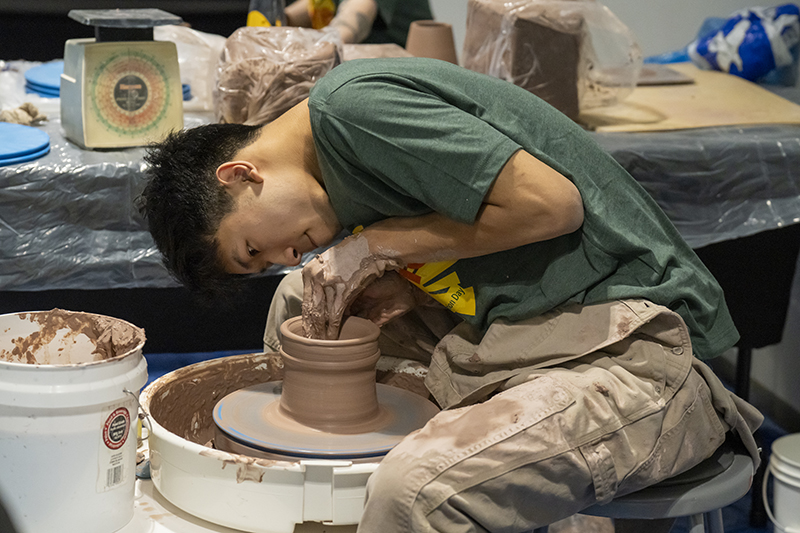 A student works on a pottery wheel at the 2024 Student Shine Presentation Day.