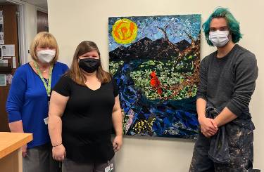 Deborah Walsh, Patricia Drummond and Will Decareaux stand in front of the donated piece. 