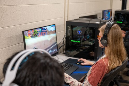 Student Natalie Buck sits at computer playing esports game.