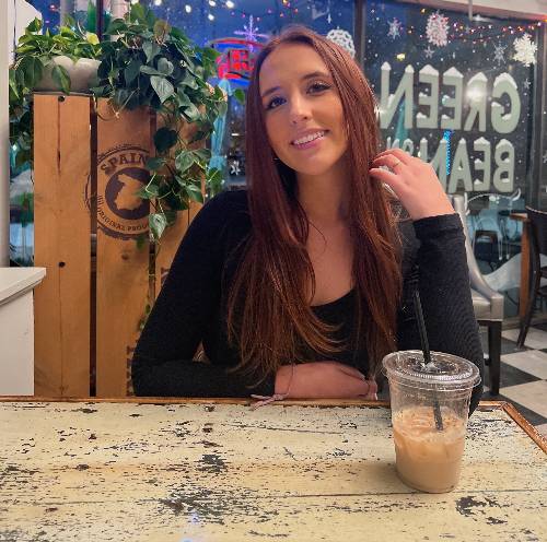 Olivia Bolick smiles while sitting at table.