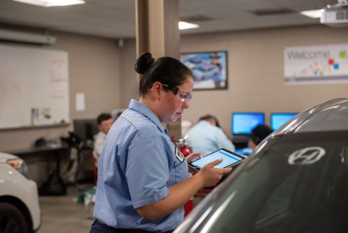 Lauren Lewis works to repair a vehicle that had been in a collision. 