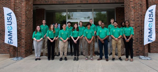 Sixteen of the 20 students in the inaugural class of the North Carolina Federation for Advanced Manufacturing Education (NC FAME) The First in Flight Chapter, pose in front of the Koury Hospitality Careers building on GTCC's campus.