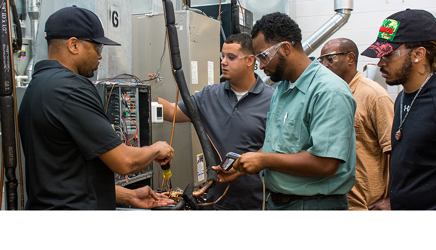 HVAC students work on a heater during class.