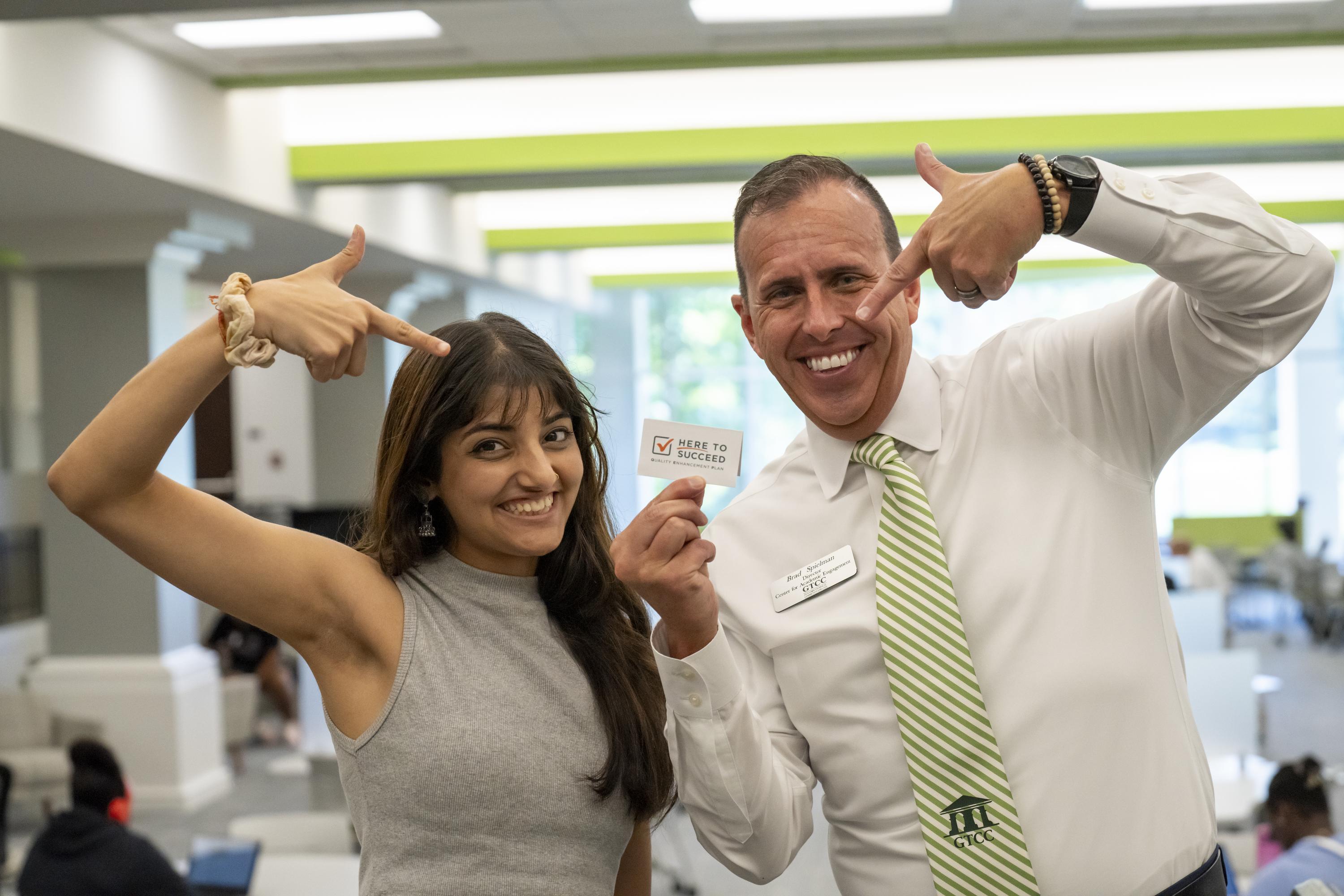 Brad Spielman, right, and a GTCC student pose for a photo with the college's QEP.