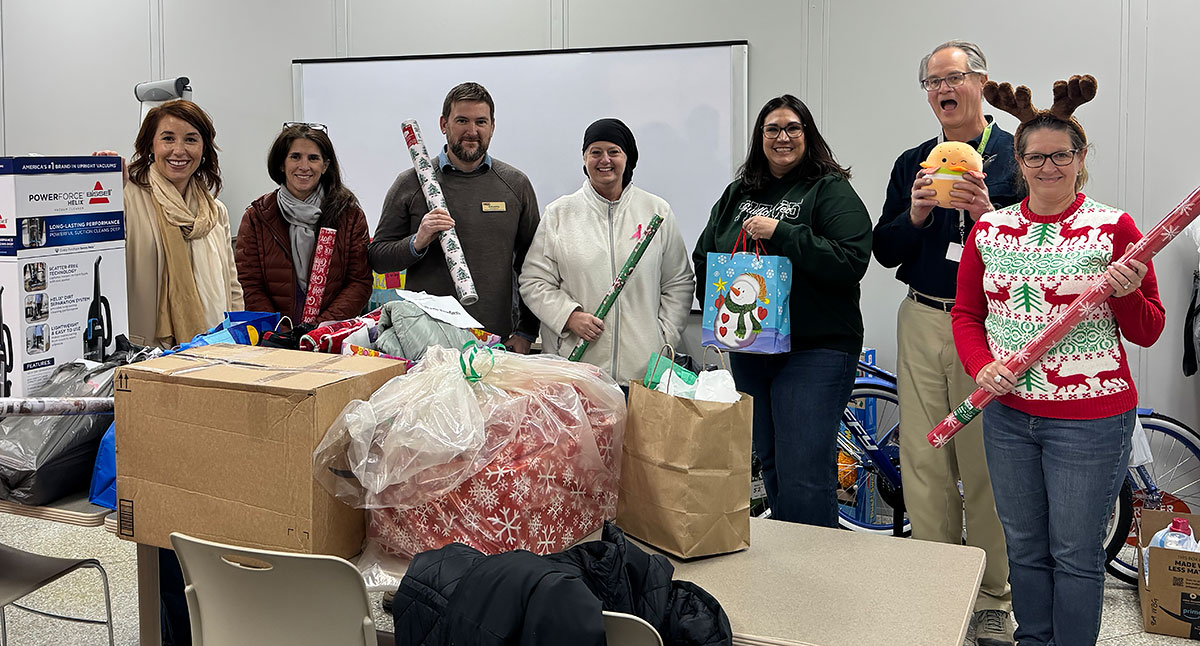 GTCC staff members stand behind gifts they collected and later delivered for adopted families in the HCC community.