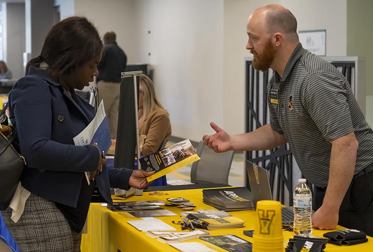 A student visits the Appalachian State table at a transfer fair.