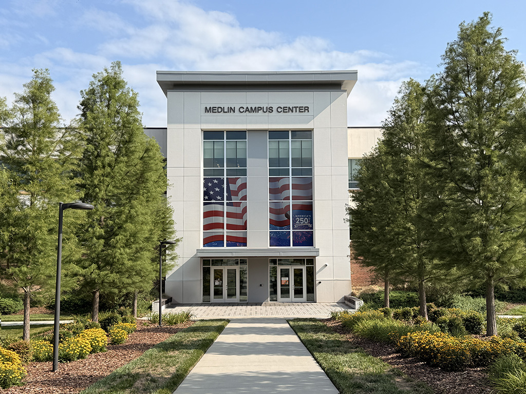 America 250 commemorative flag display over the main entrance to the Medlin Building on the Jamestown campus.